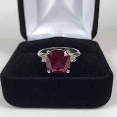 Beautiful Ruby & White Sapphire Ring * 5ct Cushion Cut Ruby measures 10mm * Brilliant Cut White Sapphire Accents measure 3mm each * 5.26cts total Gemstone weight * Beautiful Comfort Fit Shank * Solid Sterling Silver * Size 9.5 Hallmarked & Gift Ready! Matching Earrings can be found here https://www.etsy.com/listing/494099269/beautiful-cushion-cut-ruby-earrings Matching Pendant also Available! This 5ct Ruby is Laboratory Grown. It is identical to natural in every way, including Chemistry, Composi Ruby Ring Simple, Silver Solitaire Engagement Ring, Mens Ruby Ring, Silver Ruby Ring, Red Stone Ring, Trending Jewelry, Tanzanite Earrings, White Sapphire Ring, Fine Art Jewelry