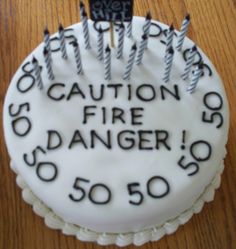 a birthday cake with candles on it that says caution fire danger 50 50 fifty five