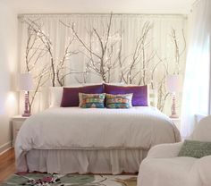 a white bed sitting in a bedroom next to a window