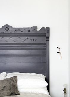 a black headboard on a bed in a room with white walls and flooring