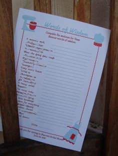 a recipe book with writing on it sitting next to a wooden fence and wood slats