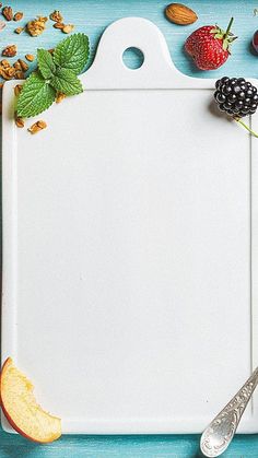 a cutting board with fruit and nuts on it next to a knife, spoon and fork