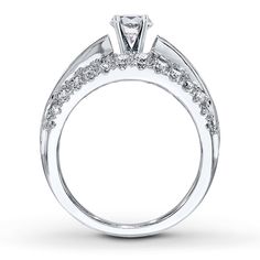 a white gold engagement ring with diamonds on the band and side stones in the center