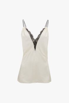 The iconic 1990s cami top is given fresh relevance in the Lace Detail Cami Top. Exquisitely cut from crepe back satin and presented in romantic Ivory, it has a lace-trimmed, deep-V neckline and a pleat beneath the bust. Double rouleau straps add a sensuous finishing touch, while a contrasting black topstitch adds a refined talking point. Styled with the Deconstructed Skirt Victoria Beckham Lace Detail Cami Top In Harvest Ivory  - Size 12 UK White Silk Camisole For Spring, White Silk Spaghetti Strap Camisole, White Satin V-neck Camisole, Formal Silk Camisole, Sleeveless Cream Silk Top, Feminine White Silk Camisole, Chic White Silk Camisole, Elegant White Tank Top For Night Out, White Sleeveless Camisole For Evening