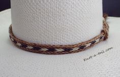 BOLD DESIGNED Horsehair bat band Cinnamon brown, black and Ivory white horsehair trimmed with a larger, cinnamon brown side matching horsehair tassel. HIGHLY NOTICEABLE, especially light colored hat. adds such a Fancy aspect to the Western design. Unique, distinctive and exceptional quality Everything you want in a Horsehair hat band. Brings out your spirit in an exclusive design that is vibrant as your western lifestyle. MEASUREMENTS * Longest length 25 inches * Shortest length about 15 inches White Brimmed Straw Hat For Ranch, White Fedora Panama Hat For Ranch, White Brimmed Straw Hat For Western-themed Events, White Straw Hat For Ranch, White Brimmed Hat Bands For Rodeo, Adjustable White Straw Hat For Rodeo, White Adjustable Panama Hat For Western-themed Events, White Handmade Adjustable Panama Hat, Handmade White Hat For Rodeo