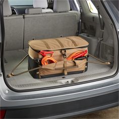 the back end of a car with an open trunk and two orange cords in it