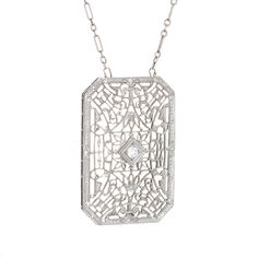 Finely detailed vintage Art Deco drop necklace (circa 1920s to 1930s), crafted in 14 karat white gold.   The drop is set with an estimated 0.04 carat Old European cut diamond (estimated at H-I colour and SI1 clarity).    The die-struck necklace features intricate and lacy filigree detail. The chain is comprised of longer bar links attached to smaller round links. The necklace measures 17 inches and sits nicely at the nape of the neck. The filigree necklace was very popular during the era and is Antique White Gold Necklace With Diamond Accents, Antique White Gold Diamond Necklace With Single Cut Diamonds, Antique White Gold Diamond Necklace, Antique White Gold Filigree Necklace, Vintage Diamond Cut Necklace In Diamond White, Vintage Diamond White Necklace With Diamond Cut, Vintage White Gold Necklace With Diamond Accents, Antique White Gold Necklace With Filigree, Antique White Gold Necklace With Intricate Design