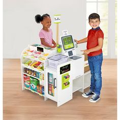 two children are playing with a toy cash register