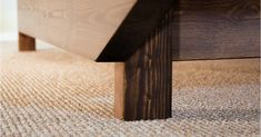 a close up of a wooden bench on a carpeted floor with the bottom section missing