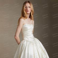 a woman in a white wedding dress posing for the camera with her hands on her hips