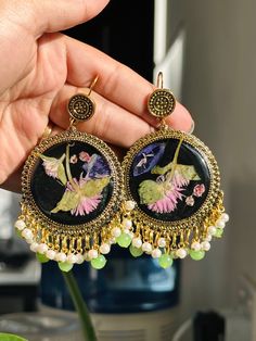 Black Floral Jhumka✨ - This statement piece was made with real flowers preserved with crystal clear epoxy resin on black background poured ib traditional golden jhumkay. - Lightweight black and golden jhumkay embellished with dangling white and green beads. 🌱handmade with love🌱 Golden Jhumka Earrings, Golden Jhumka, Crystal Clear Epoxy Resin, Flowers Resin, Clear Epoxy Resin, Clay Jewellery, Clear Epoxy, Green Beads, Jhumka Earrings