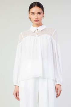 A lace paneled yoke accents this floaty blouse designed with a classic collar at the neck. It's relaxed and airy, enhanced by subtle gathers that create a beautiful drape. •Collared neckline •Button closure •Long sleeves •Elasticized cuffs •Relaxed fit Item number 2430145100% Polyester White Feminine Blouse With Sheer Sleeves, Feminine Sheer Sleeves Top For Daywear, White Lace Collar Top For Daywear, Chic Collared Lace Top Blouse, White Lace Top With Ruffled Collar, White Lace Cuffs Blouse For Work, Feminine Blouse With Lace And Ruffled Collar, Feminine White Blouse With Blouson Sleeves, Feminine Lace Top With Lace Cuffs For Daywear