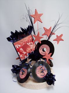 an arrangement of records and star decorations on a table top with a card in the center