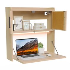 a laptop computer sitting on top of a wooden desk