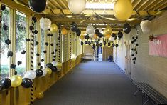 the hallway is decorated with black, white and gold balloons that are hanging from the ceiling