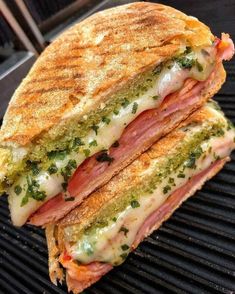 a grilled sandwich with meat, cheese and pesto on the side is sitting on an outdoor grill