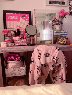 a vanity with pink towels and other items on top of it in a room that is decorated