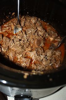 the food is being cooked in the crock pot with tongs and sauce on top