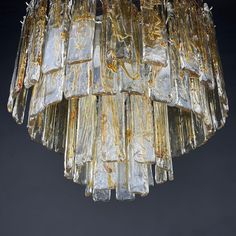 a chandelier made out of glass blocks hanging from a ceiling fixture in a dark room