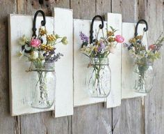 three mason jar wall hangings with flowers in them