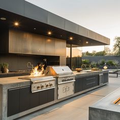 an outdoor kitchen with grill and seating area