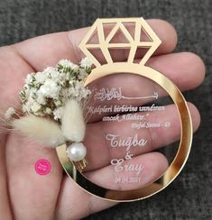 a person holding a ring with flowers in it