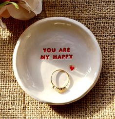 a ring dish with the words you are my happy written on it next to a flower