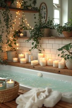 candles are lit in the bathtub surrounded by potted plants and other greenery