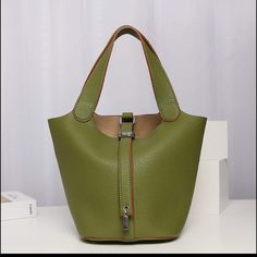 This Cute Olive Green Bucket Bag Has A Soft Texture Leather And Comes With A Cute Pad Lock Charm! This Chic Bag Is The Perfect Blend Of Fashion And Function. -Lightweight -Olive Green - 15in H X 11.5 In W -Faux Leather Elegant Green Bucket Bag With Large Capacity, Elegant Green Large Capacity Bucket Bag, Green Bucket Satchel, Green Bucket Shoulder Bag With Detachable Handle, Green Bucket Hobo Bag For Daily Use, Green Bucket Bag With Removable Pouch, Green Bucket Shoulder Bag With Handles, Green Bucket Hobo Bag, Everyday Green Satchel With Hasp Closure