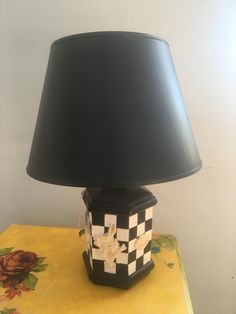 a lamp that is sitting on top of a table with a flowered box underneath it