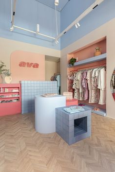 the inside of a clothing store with pink and blue walls