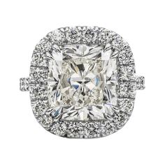 a cushion cut diamond surrounded by halos and pave set in 18k white gold