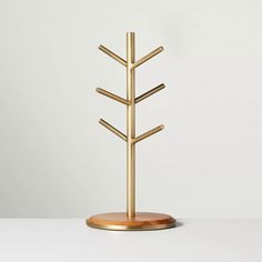 a gold metal tree on a wooden stand