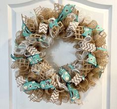 a wreath with burlocks and bows hanging on the front door's side