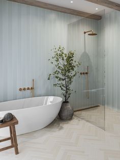 a white bath tub sitting next to a walk in shower under a wooden ceiling mounted faucet