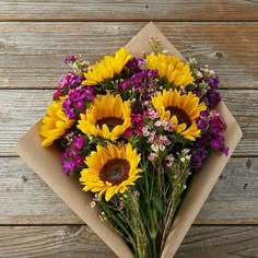 a bouquet of sunflowers and purple flowers