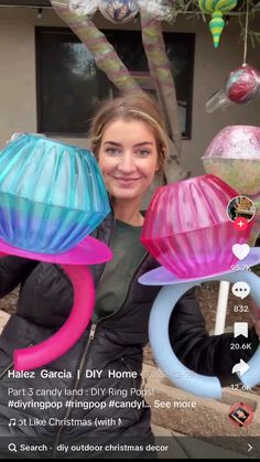 the girl is holding three colorful hats