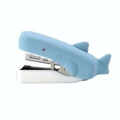 a blue shark shaped stapler sitting on top of a white table