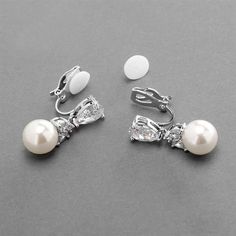 Pearl Drop Bridal Earrings These elegant wedding earrings sparkle with pear shaped Cubic Zirconia detailing and a 10mm soft ivory pearl drop. These petite silver rhodium plated drop earrings are a beautiful accessory to complete your wedding day ensemble. Beautiful for the bride or her bridesmaids. These beautiful earrings are available in both pierced and clip on styles. Size: 1" long. Color: Silver/ Ivory. Style: 4490E. Please allow 1 week for delivery. Shipping Policy . Return Policy. Earring For Bride, Pearl Drop Earrings Bridal, Silver Earrings Wedding, Earring Pearl, Silver Bridal Earrings, Bridal Wedding Earrings, Geode Earrings, Pearl Earrings Wedding, Wedding Earrings Drop