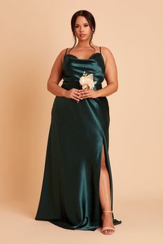 a woman in a long green dress posing for the camera with her hand on her hip