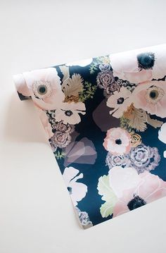 a blue and pink flowered wallpaper with white flowers on the bottom half of it