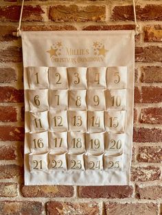 a wall hanging on the side of a brick building with numbers and times printed on it