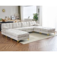 a large sectional couch sitting on top of a rug in a living room next to a window