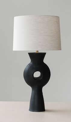 a black table lamp with a white shade on it