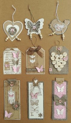 many different tags are hanging on a brown surface with white and pink decorations in the shape of hearts