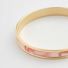 Infuse your style with the spirit of summer with the Whispering Sands Printed Bangle in Lotus Pink. Crafted with meticulous detail, this gold bangle embodies nostalgic notions of a tranquil day at the seaside. Its whimsical design captures the essence of nature's beauty in a contemporary and chic style, making it a delightful addition to any ensemble. Key Features: 14ct gold-plated brass bangle, acrylic printed 67mm diameter, 9mm width Comes in a gift box with cotton pouch Baking Essentials Tools, Cottage Socks, Irish Knit Sweaters, Tweed Purse, Wrendale Designs, Tartan Blanket, Irish Cottage, Brass Bangle, Candle Warmer