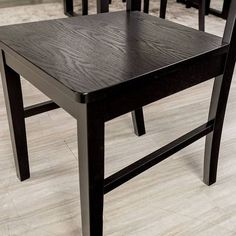 four black chairs sitting on top of a hard wood floor