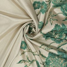 the fabric is green and white with flowers on it, as well as metallic foil