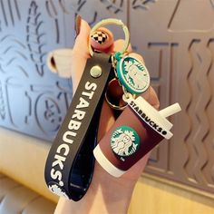 starbucks keychain with starbucks logo on it being held by a woman's hand