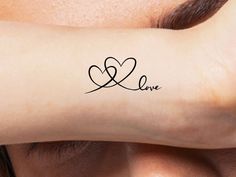 a woman's arm with the word love written on it and a heart in the middle